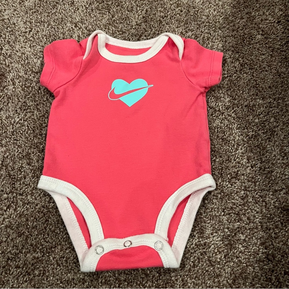 Pink, White, and Blue Nike Onesie Blue Heart with a Nike Swoosh
